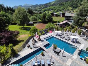 an aerial view of a swimming pool with chairs and a resort at Hôtel Le Labrador 1971 in Les Gets