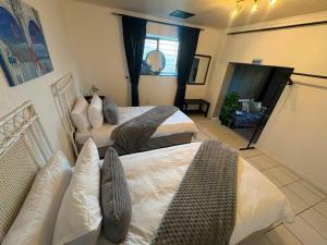 a bedroom with two beds and a living room at The Sync Inn in Gqeberha +17 photos