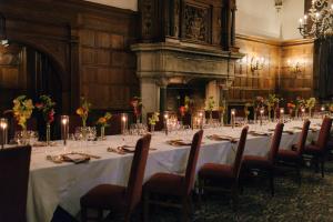 a dining room with a long table and chairs at Rhinefield House Hotel in Brockenhurst +51 photos