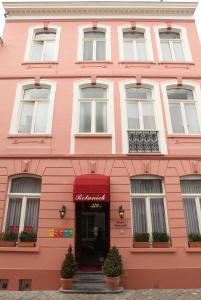 un edificio rosa con plantas delante en Hotel Botaniek, en Brujas