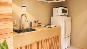 a kitchen with a white refrigerator and a microwave at Villa KULM in Minamiawaji