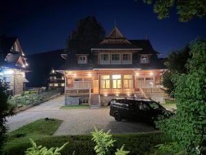 a car parked in front of a house at night at Owca na Polanie in Zakopane