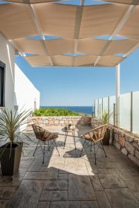 a patio with chairs and a table on a building at Tholos Home Sfakia in Hora Sfakion