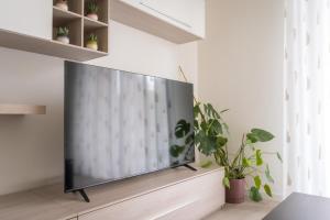a flat screen tv sitting on a stand in a living room at Bergamo Hideout in Bergamo