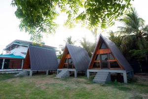 a group of three small houses sitting next to a building at Area 51 Arugambay in Arugam Bay