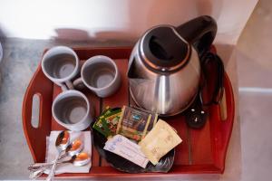 a tray with a tea pot and cups and utensils at Area 51 Arugambay in Arugam Bay