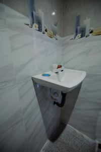 a bathroom with a white sink on a wall at Area 51 Arugambay in Arugam Bay