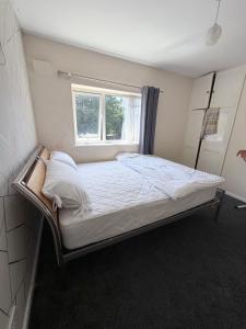 a bed in a room with a window at Nuneaton 3 Bedroom House with Drive and Garden Sleeps 5 in Attleborough