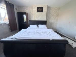 a large bed in a room with avertisement at Nuneaton 3 Bedroom House with Drive and Garden Sleeps 5 in Attleborough