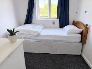 a small bed in a room with a window at Nuneaton 3 Bedroom House with Drive and Garden Sleeps 5 in Attleborough
