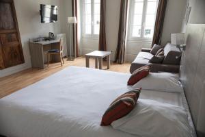 a bedroom with a large bed with pillows on it at Hôtel de la Poste Restaurant Benjamin Linard in Pouilly-en-Auxois