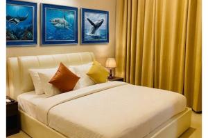 a bedroom with a white bed with pictures of dolphins at Ocean Stay & Dive in Fenfushi