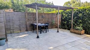 a patio with a table under a canopy at "Villa du Pin" idéalement situé Ruoms à pieds, voie verte in Ruoms