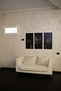 a white couch in a room with four pictures on the wall at ASTRUM b&b in Cosenza +36 photos