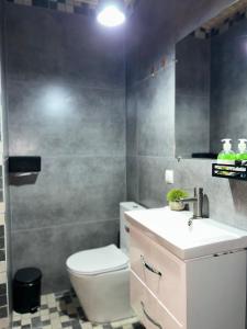a bathroom with a white toilet and a sink at RestList in Haghpat
