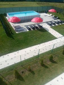 an overhead view of a pool with red umbrellas at LOFT HOUSE in Skhidnitsa