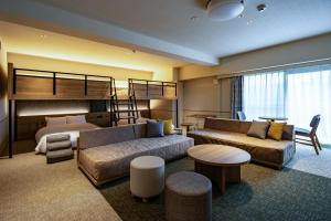 a hotel room with a bunk bed and a living room at BbyC HOTEL Kusatsu in Kusatsu