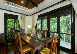 a dining room with a wooden table and chairs at Katamanda Villa Chanti Pool Villa Kata in Kata Beach