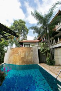 a swimming pool in front of a house at Katamanda Villa Chanti Pool Villa Kata in Kata Beach