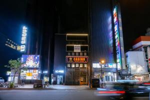 a busy city street at night with neon signs at Open記念セール!! AXIS STAY asahikawa36 旭川街中に佇むLuxury Stay in Asahikawa