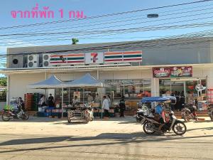 a person riding a motorcycle in front of a store at MWELL House in Ban Klang