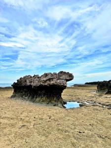 a rock formation on a beach with a cloudy sky at Hon Do Eco Retreat in Mỹ Thanh