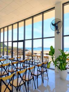a room with tables and chairs and large windows at Hon Do Eco Retreat in Mỹ Thanh