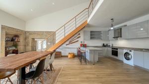 a kitchen and dining room with a table and a staircase at Casa do Sobrado ByAlta in Caparrosa