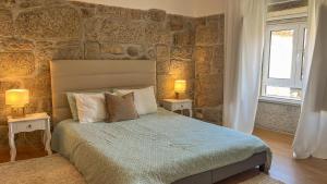 a bedroom with a bed with two tables and two lamps at Casa do Sobrado ByAlta in Caparrosa
