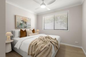 a white bedroom with a bed and a window at Blue Gum Hideaway Pet friendly Fire Pit in Coolum Beach +16 photos