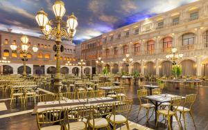 a restaurant with tables and chairs in a building at Kassland Resort & Spa -By Kassland Hotels in Ma'ale Adumim