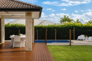a patio with a fence and a table and chairs at Blue Gum Hideaway Pet friendly Fire Pit in Coolum Beach