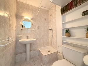 a white bathroom with a sink and a toilet at Studio plein centre et parking in Châtel-Guyon +15 photos