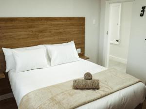 a bedroom with a white bed with a wooden headboard at Railway Hotel in Wellington