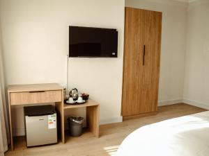 a room with a bed and a tv on the wall at Railway Hotel in Wellington
