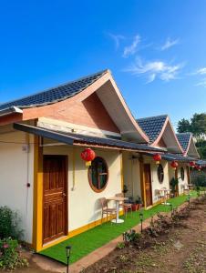 a house with a table and chairs in the yard at ฮ่องเต้รักไทยรีสอร์ท in Ban Rak Thai