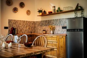 a kitchen with a wooden table and a refrigerator at Casa Sunetul Padurii din Belis Apuseni in Călăţele