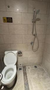 a bathroom with a toilet and a shower at Apartemen Roseville at BSD by Kenkei in Dadap +1 photo
