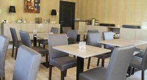 a restaurant with tables and chairs in a room at Villa Amylia & gratis parking in Wenduine