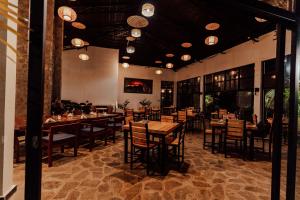 a restaurant with tables and chairs in a room at Grotta Resort in Gasanze
