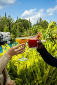 two people holding up two cocktails in their hands at Grotta Resort in Gasanze +19 photos