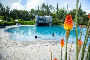 two people swimming in a pool at a resort at Grotta Resort in Gasanze