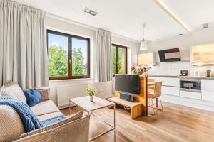 a living room with a couch and a tv at Apartamenty Oaza Superior Zakopane in Zakopane
