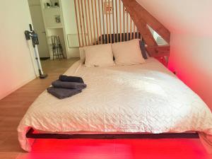 a bedroom with a white bed with a wooden frame at Jacuzzi privé - Netflix - Wi-Fi - parking gratuit in Châtel-Guyon