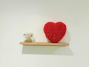 a red heart is sitting on a shelf at Jacuzzi privé - Netflix - Wi-Fi - parking gratuit in Châtel-Guyon
