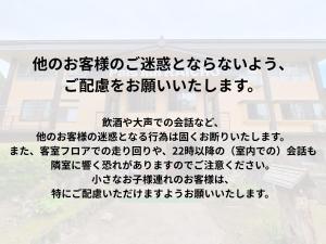 a sign with chinese writing on a wall at Pals Inn Raicho in Hakuba