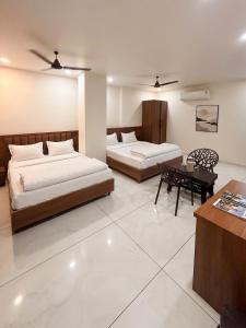 a bedroom with two beds and a table in it at Hotel Vivanta in Bānswāra