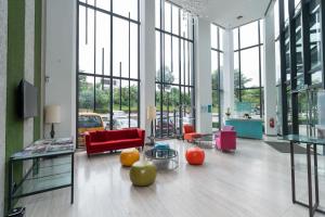 a lobby with red chairs and tables and windows at Kingston Hotel 22 - Cheras, Kuala Lumpur in Kuala Lumpur +38 photos