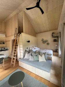 a bedroom with a bed with a ladder and a table at SeeLaVie - Tiny Houses am Mattsee in Mattsee