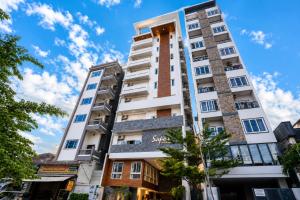 a tall white building with a blue sky in the background at Sopor Resident in Phnom Penh